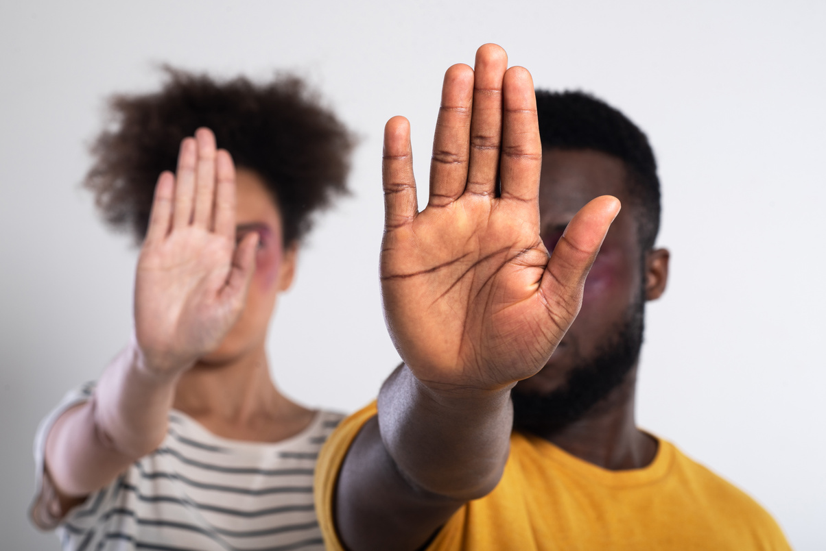 African-American couple gesturing "Stop" racism