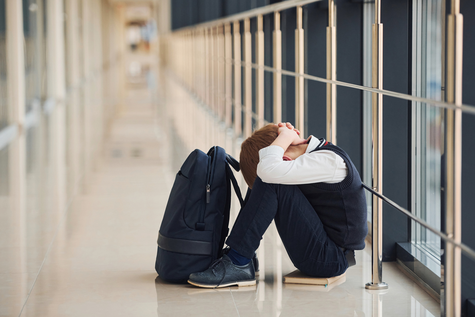Boy in Uniform Sitting Alone with Feeling Sad at School. Conception of Harassment